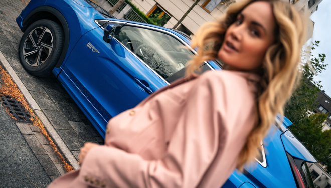 Pourquoi Choisir Mitsubishi Motors France ? Femme devant un Mitsubishi bleu